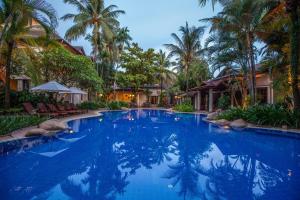 万象瑟塔宫酒店的度假村内一座种有棕榈树的大型游泳池