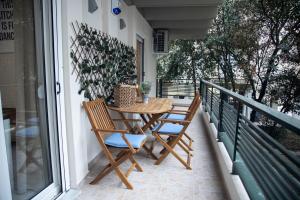 塞萨洛尼基Fobillo Apartment at Charilaou的阳台的门廊配有桌椅