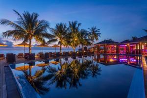 芭环礁迪古法鲁岛度假酒店的夜间带游泳池和棕榈树的度假村