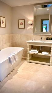 戈里玛尔菲尔德酒店的带浴缸、水槽和镜子的浴室