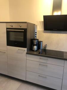 多特蒙德Zentrale Unterkunft in Dortmund City的厨房配有白色橱柜和黑烤箱。