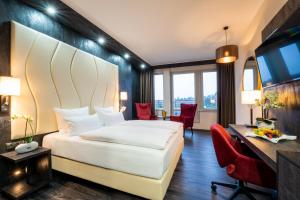 什未林PLAZA Premium Schwerin Sure Hotel Collection by Best Western的酒店客房,配有一张床、一张桌子和椅子