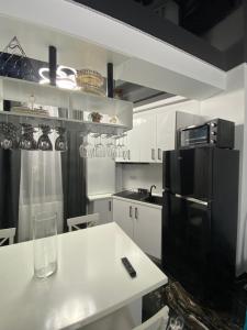 北马马亚-讷沃达里Apartament 105 - HF Building Resort的厨房配有白色桌子和黑色冰箱。