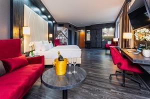 什未林PLAZA Premium Schwerin Sure Hotel Collection by Best Western的酒店客房配有一张床和红色家具