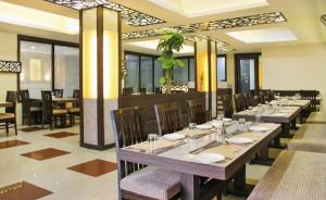 阿格拉Om Sai Nath Hotel & Restaurant By WB Inn的一间带长桌和椅子的用餐室