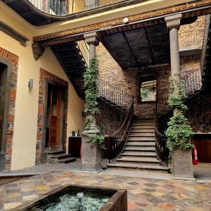 普埃布拉Milo Collection Hotel的一座拥有水池和楼梯的建筑