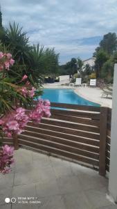 弗雷瑞斯Mimosas - villa的游泳池旁的木栅栏,有粉红色的花朵