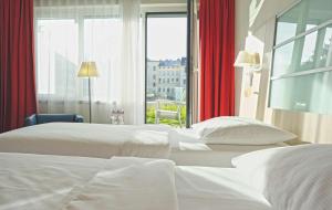 林茨林茨雷迪森公园客栈的配有窗户的酒店客房内的两张床