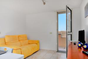 奥尔比亚L'appartamento di Giusi的客厅配有黄色沙发和书桌