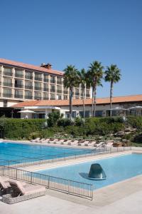 荷兹利亚丹阿卡迪亚荷兹利亚酒店的一座大型酒店,设有游泳池和棕榈树