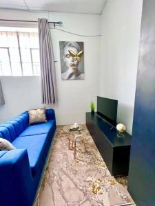 约翰内斯堡Cosy Apartment next to Maboneng的客厅配有蓝色的沙发和桌子