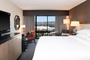 圣地亚哥Sheraton Mission Valley San Diego Hotel的一间酒店客房,设有一张大床和一个大窗户