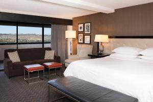 圣地亚哥Sheraton Mission Valley San Diego Hotel的酒店客房设有一张大床和一张沙发。