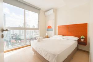 巴拿马城Boutique Apartments Panamá Coco del Mar的一间卧室设有一张大床和一个大窗户