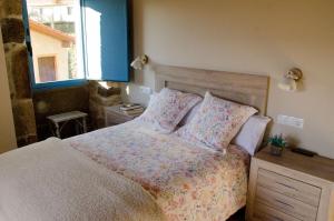 奥伦塞A Casa da Fonte的卧室配有带枕头的床铺和窗户。