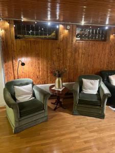 BroakullaFerienhaus in Broakulla mit Sauna的客厅配有两把椅子和一张桌子