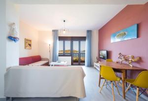 奥马斯帕纳吉亚斯#FLH - Nereus & Oceanus Beachfront Apartments, Lagonisi Beach的配有一张床和一张桌子及椅子的房间