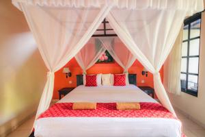 佩母德兰巴厘佩母得兰吉里萨里旅馆的一间卧室配有红色和白色枕头的床