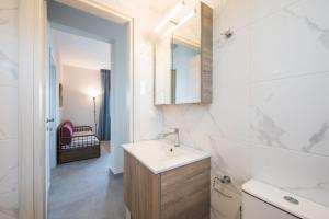 奥马斯帕纳吉亚斯#FLH - Nereus & Oceanus Beachfront Apartments, Lagonisi Beach的白色的浴室设有水槽和镜子