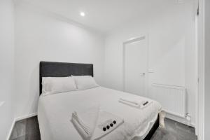 墨尔本Grosvenor 3121 Richmond的一间卧室配有一张白色的床和黑色床头板