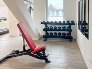 黑尔斯布鲁克DORMERO Hotel Hersbruck的一间健身房,里面设有红色椅子