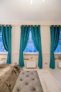 伦敦Haus of Mason的一间设有蓝色窗帘的房间,窗户前设有一张大床