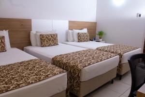 萨尔瓦多Quality Hotel & Suítes São Salvador的一间酒店客房,房间内设有三张床