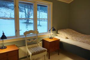 SæbøMoonvalley Lodge - stort & koselig hus - Måndalen的一间卧室设有一张床、一个窗口和一把椅子