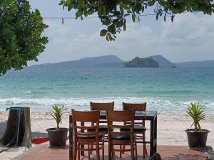 瓜隆岛SCARLET SAILS BUNGALOW的海滩上的桌椅
