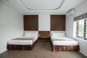 Nghĩa LộNhà Nghỉ Ngọc Anh的带2扇窗户的客房内的2张床