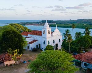 伊塔马拉卡Villa Velha Flats的一座以海洋为背景的岛屿教堂