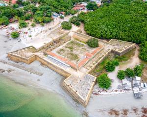 伊塔马拉卡Villa Velha Flats的海滩上一座建筑废墟的空中景观