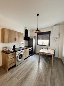 隆达Apartamentos - Naranja的厨房配有桌子和炉灶。 顶部烤箱