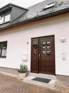 安娜贝格-布赫霍尔茨Ferienwohnung zum Schreckenberg的一座带木门的房屋,上面有花圈