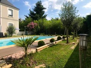 卢瓦尔河畔圣西Villa de 6 chambres avec piscine privee jardin clos et wifi a Saint Cyr sur Loire的一座房子旁的院子内的游泳池