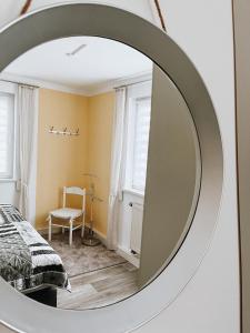 安娜贝格-布赫霍尔茨Ferienwohnung zum Schreckenberg的卧室内的镜子,配有一张床和椅子