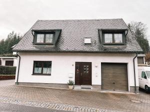 安娜贝格-布赫霍尔茨Ferienwohnung zum Schreckenberg的白色的房子,设有2扇窗户和车库