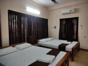 特里凡得琅Sreevalsam Guest House的客房设有两张床和窗户。
