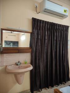 特里凡得琅Sreevalsam Guest House的浴室设有水槽和黑色淋浴帘