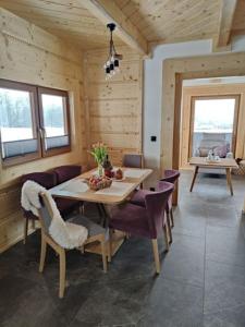 斯派特克维瑟beskid house的一间带桌子和紫色椅子的用餐室