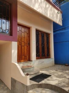 特里凡得琅Sreevalsam Guest House的一座房子,设有两扇门,铺有石地板