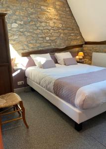 沙托纳城堡酒店的一间卧室设有一张大床和石墙