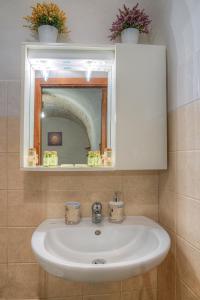蒙塔尔巴诺Il Trulletto的浴室设有白色水槽和镜子