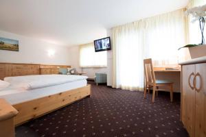 奥蒂塞伊皮内酒店的酒店客房配有一张床、一张书桌和一台电视。