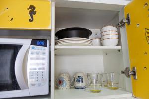 巴拉那州蓬塔尔Pousada Guaricana的厨房配有微波炉、盘子和玻璃杯