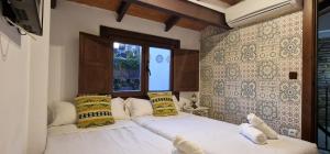 格拉纳达PATRIMONIO ARABE VISTA A LA ALHAMBRA的一间卧室设有两张床和窗户。