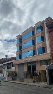 昆卡HOTEL 4 RIOS的街道上拥有蓝色窗户的酒店建筑