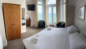 滕比克拉伦斯酒店的酒店客房带大型白色床和窗户。