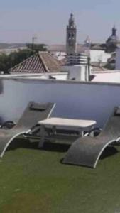 埃希哈ático con terraza- solarium的屋顶上两把椅子和一张桌子