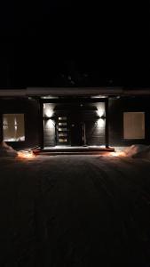 伊纳利Villa Paatari, Inari (Paadarjärvi)的黑暗中有两个灯的建筑